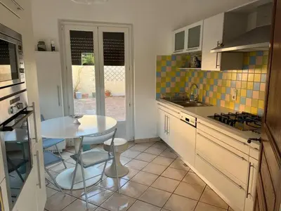 a kitchen with a white table and a table and chairs at MCC House, cozy accommodation with terrace and BBQ in Quillan