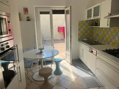 a kitchen with a white table and a table and chairs at MCC House, cozy accommodation with terrace and BBQ in Quillan