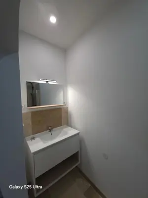 a bathroom with a white sink and a mirror at YZA Lodge 2026 in Castelnaudary