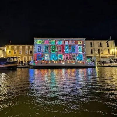 a building with christmas lights on the water at night at YZA Lodge 2026 in Castelnaudary