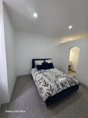 a bedroom with a bed in a white wall at YZA Lodge 2026 in Castelnaudary