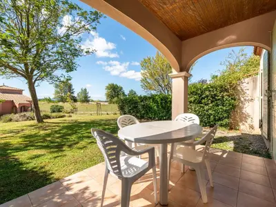 a patio with a table and chairs on a porch at P Minervois J N07 Villa 3P4 in Homps