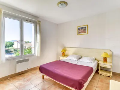a bedroom with a large bed and a window at P Minervois J N07 Villa 3P4 in Homps