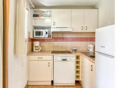 a kitchen with white cabinets and a white refrigerator at P Minervois J N07 Villa 3P4 in Homps