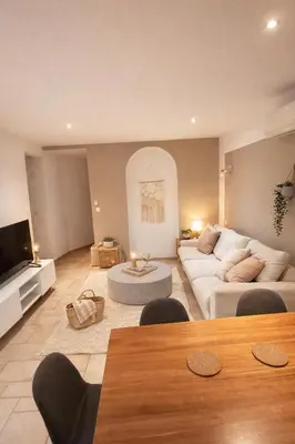 a living room with a white couch and a table at Magnifique T3 - à 5 min de la Cité Médiévale in La Celle-sous-Gouzon