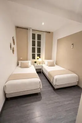 a room with two beds and a window at Magnifique T3 - à 5 min de la Cité Médiévale in La Celle-sous-Gouzon