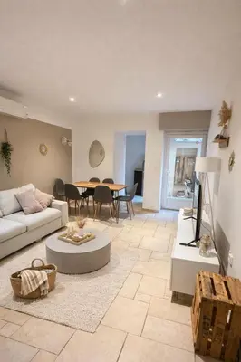 a living room with a couch and a table at Magnifique T3 - à 5 min de la Cité Médiévale in La Celle-sous-Gouzon