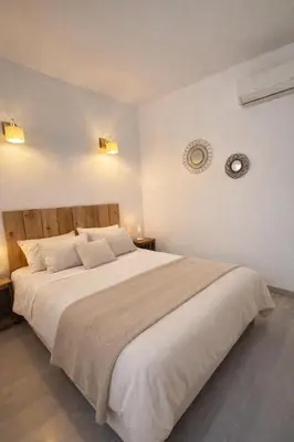 a bedroom with a large bed with white sheets at Charmant T2 - à 5 min de la Cité Médiévale in Carcassonne