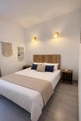 a bedroom with a large white bed with blue pillows at Charmant T2 - à 5 min de la Cité Médiévale in Carcassonne