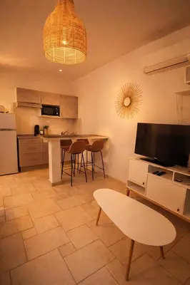 a kitchen with a table and chairs and a television at Charmant T2 - à 5 min de la Cité Médiévale in Carcassonne