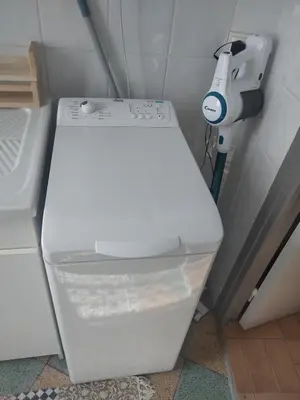 a white toilet in a bathroom with a light at Studio à 5 min des halls in Narbonne