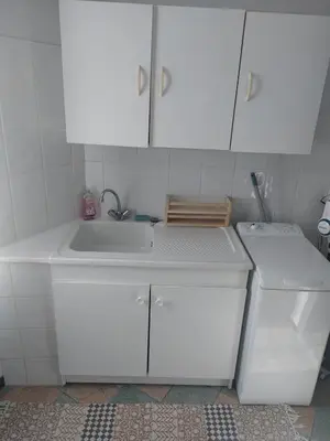 a white kitchen with a sink and a dishwasher at Studio à 5 min des halls in Narbonne