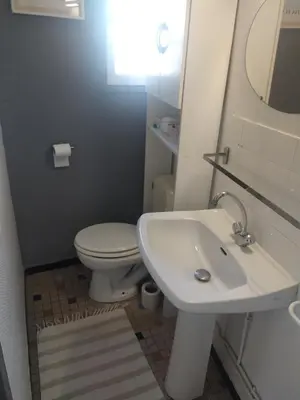 a bathroom with a white toilet and a sink at Studio à 5 min des halls in Narbonne