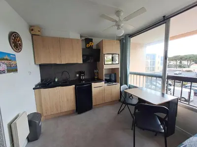 a kitchen and dining room with a table and a view at Studio rénové avec piscine et accès direct plage in Gruissan