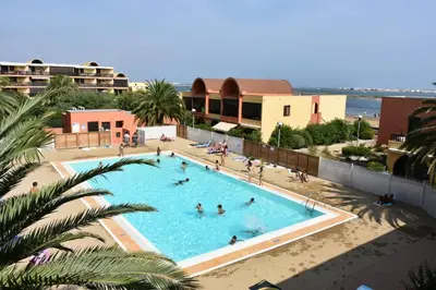an overhead view of a swimming pool with people in it at Studio rénové avec piscine et accès direct plage in Gruissan