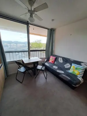 a room with a bed and a table with chairs at Studio rénové avec piscine et accès direct plage in Gruissan