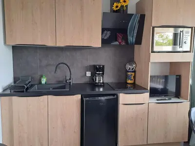 a small kitchen with a sink and a dishwasher at Studio rénové avec piscine et accès direct plage in Gruissan