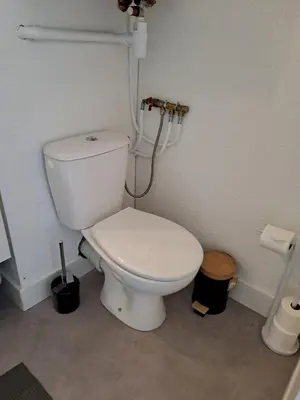 a bathroom with a white toilet in a room at Studio rénové avec piscine et accès direct plage in Gruissan