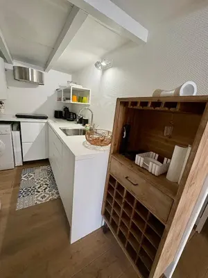 a kitchen with white cabinets and a sink at Pavillon rénové avec terrasse & piscine in Gruissan