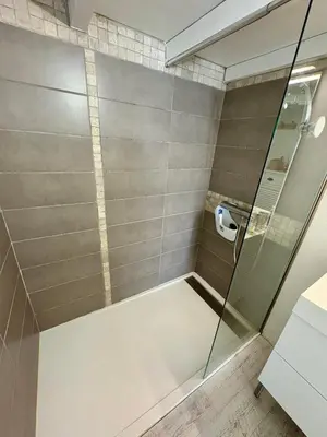 a shower with a glass door in a bathroom at Pavillon rénové avec terrasse & piscine in Gruissan