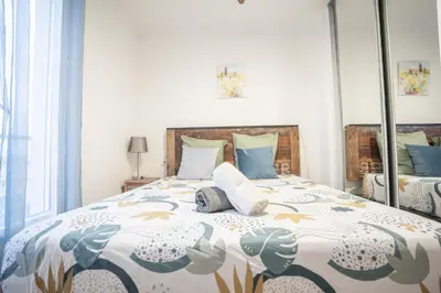 a bedroom with a large bed with blue pillows at Terrasse et parking a 500m de la Cite AR in Carcassonne