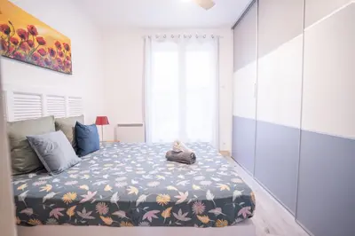 a bedroom with a bed with a blue and white blanket at Terrasse et parking a 500m de la Cite AR in Carcassonne