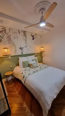 a bedroom with a large white bed with a ceiling fan at Le Colibri Carcassonne Meublé de Tourisme 3 Etoiles in Carcassonne