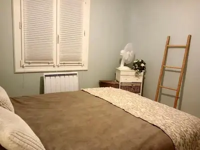 a bedroom with a bed and a window and a ladder at Villa Pamprenelle in Poilhès