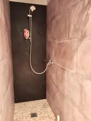 a shower in a bathroom with a black wall at Villa Pamprenelle in Poilhès