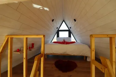 a bed in a small room with a window at L'Amoré - Cabane en A avec spa privatif in Durban-Corbières