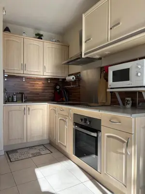 a kitchen with white cabinets and a microwave at NOUVEAU 