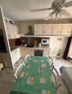 a kitchen with a green table and chairs in a room at NOUVEAU 