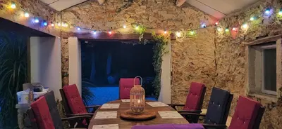 a dining room with a table and chairs and lights at Domaine De L'aube Des Temps in Raissac-dʼAude