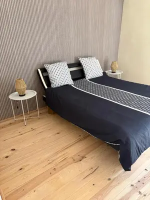 two beds in a room with two tables at Ma petite chaumière in Bouilhonnac