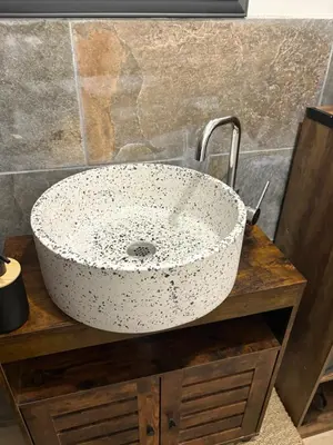 a white bowl sink on a wooden counter in a bathroom at Ma petite chaumière in Bouilhonnac