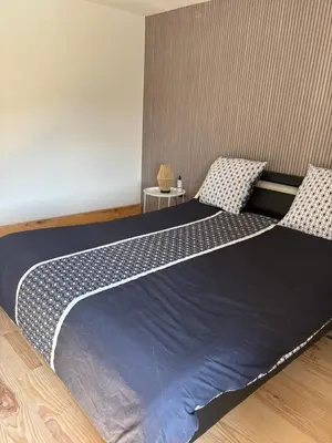 a bedroom with a large bed with two chairs at Ma petite chaumière in Bouilhonnac