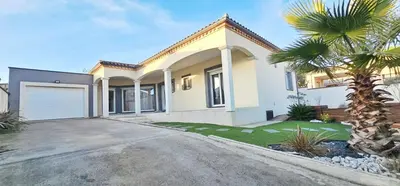 a house with a palm tree in the driveway at Maison vacances avec piscine Pennautier in Pennautier