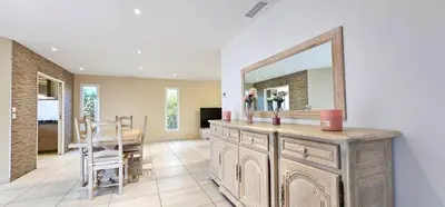 a bathroom with a large mirror on a wooden dresser at Maison vacances avec piscine Pennautier in Pennautier