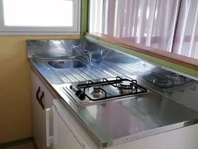 a kitchen counter with a stove and a sink at Chalet familial 5 pers avec terrasse à Axat - API-1-52-1152 in Axat