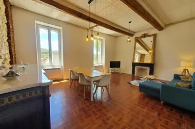 a living room with a table and a blue couch at Via Domitia Spacieuse maison 5 chambres in Portel-des-Corbières