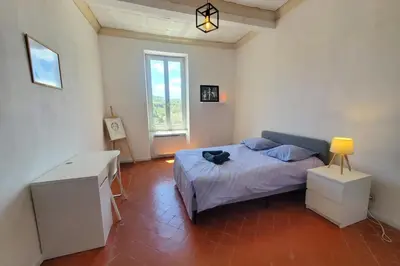 a bedroom with a bed and a desk and a window at Via Domitia Spacieuse maison 5 chambres in Portel-des-Corbières