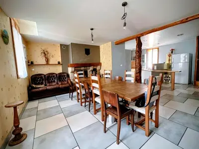 a kitchen and dining room with a wooden table and chairs at Gîte La Bastide Saint-Roc Haute Vallée de l'Aude in Antugnac