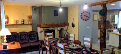 a dining room with a table and a fireplace at Gîte La Bastide Saint-Roc Haute Vallée de l'Aude in Antugnac
