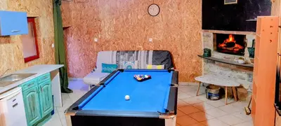 a kitchen with a pool table and a fireplace at Gîte La Bastide Saint-Roc Haute Vallée de l'Aude in Antugnac