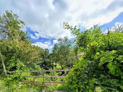 a wooden fence in a field with trees at Gîte La Bastide Saint-Roc Haute Vallée de l'Aude in Antugnac
