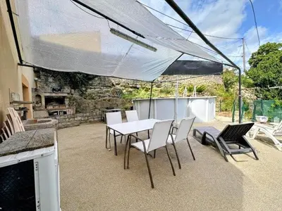 a patio with a white table and chairs on a patio at Gîte La Bastide Saint-Roc Haute Vallée de l'Aude in Antugnac