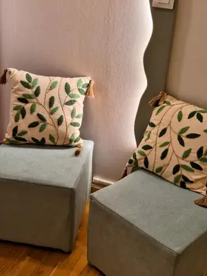 a room with a couch and a pillow and a ottoman at Le Damier in Castres