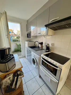 a kitchen with a stove and a sink and a dishwasher at Pavillon familial à deux pas de la plage in Gruissan