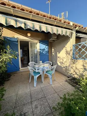 a table and chairs on the patio of a house at Pavillon familial à deux pas de la plage in Gruissan