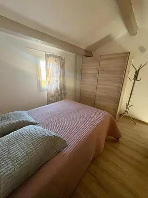 a bedroom with a large bed and a window at Pavillon familial à deux pas de la plage in Gruissan